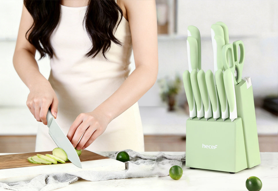 Woman slicing a lime on a wooden cutting board next to a pastel green Hecef knife block set on a marble countertop.