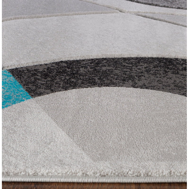 Tapis rectangulaire 9x12 turquoise aux motifs géométriques sculptés à la main, en polyester doux à poils courts, pour salon ou chambre.
