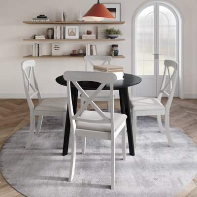 Ensemble de salle à manger 5 pièces avec table ronde noire et chaises à dossier haut en X rembourrées blanches