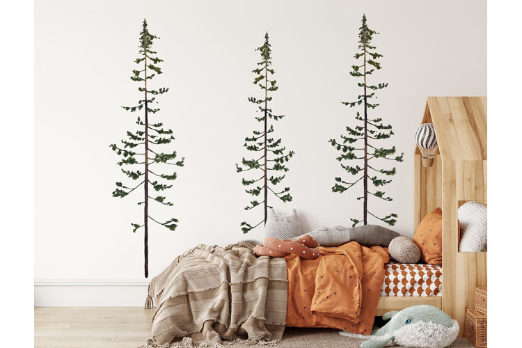 pine tree decal next to a childs bed that has orange and brown bedding
