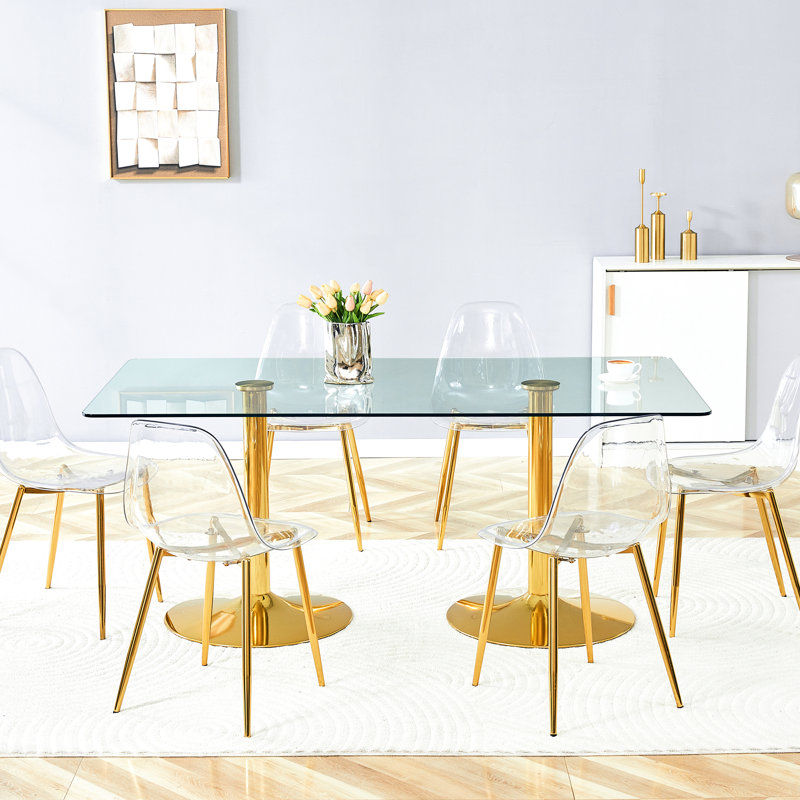 Chaises en plastique transparent avec pattes en métal doré assorties à une table en verre trempé de 180 cm (71 pouces), une solution de repas stable et fonctionnelle. Table de 6 pieds, idéale pour les réunions de famille.