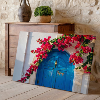 Toile, art mural orné d'une grande porte arquée bleue vieillie et ornée d'une grande cascade de vignes de bougainvilliers