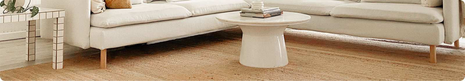 Low angle of a white theme living room with a natural color jute rug.