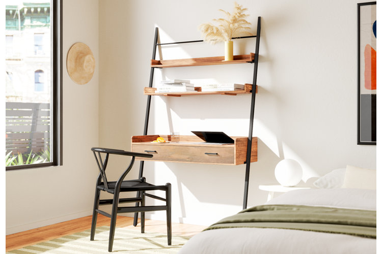 Leaning ladder desk and wooden chair in bedroom.