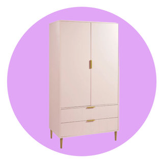 Blush pink two-door wardrobe with two bottom drawers and gold-toned metal hardware on a circular purple background.