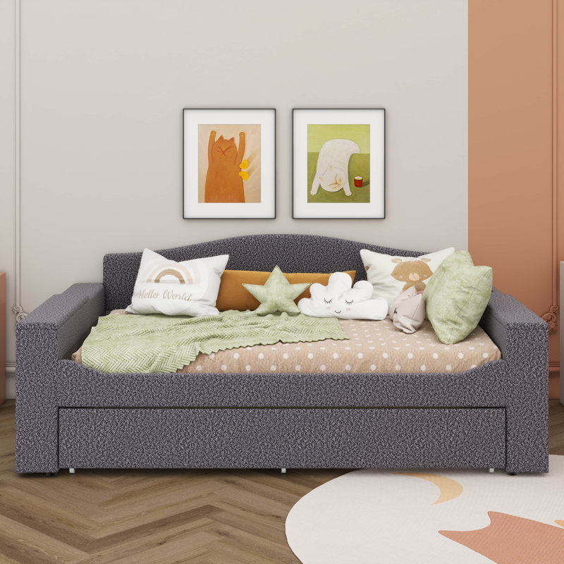 Un lit de jour rembourré avec accoudoirs de rangement, un lit gigogne sous le lit et un système audio Bluetooth de pointe