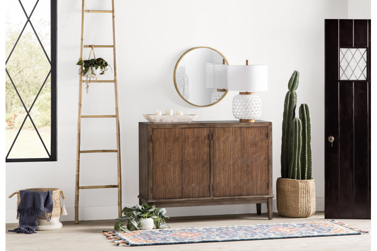 Bamboo blanket ladder with hanging plant hanging from it in entry way