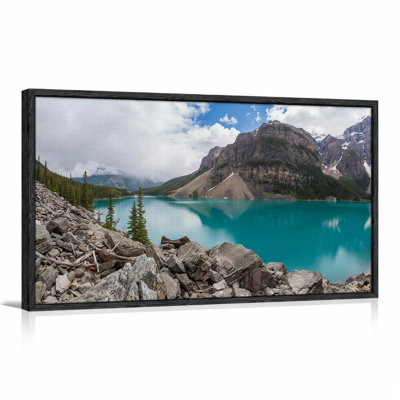 Tableau sur toile représentant un lac de montagne turquoise avec rivage rocheux et pins