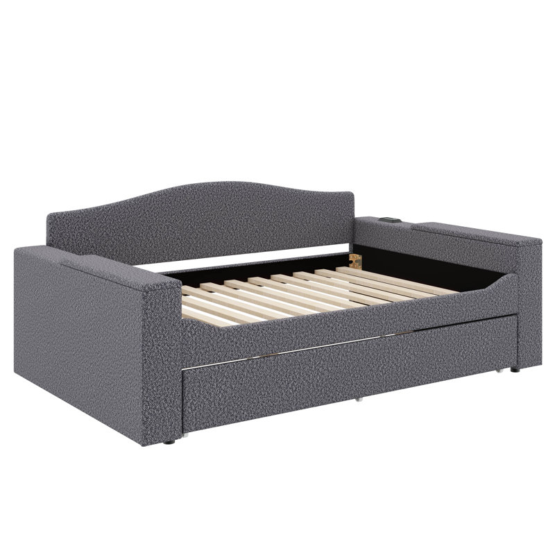 Un lit de jour rembourré avec accoudoirs de rangement, un lit gigogne sous le lit et un système audio Bluetooth de pointe