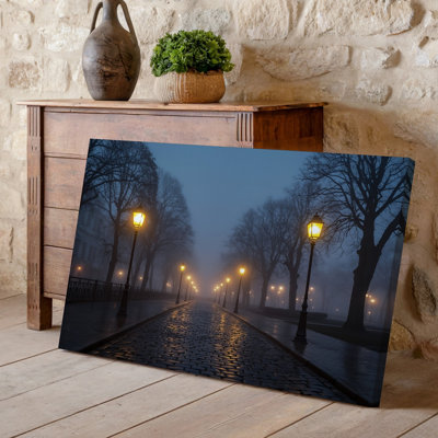 Toile «A Misty Evening Scene» avec une rangée de lampes rétro d'art mural diffusant une chaude lumière rougeoyante le long d'une toile réfléchissante humide