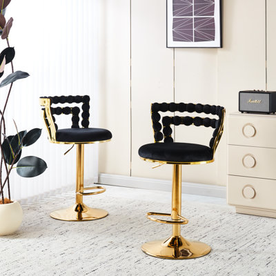 Élégant tabouret de bar à pieds tubulaires en fer doré avec revêtement en velours noir et position de soutien pour un décor commercial élégant