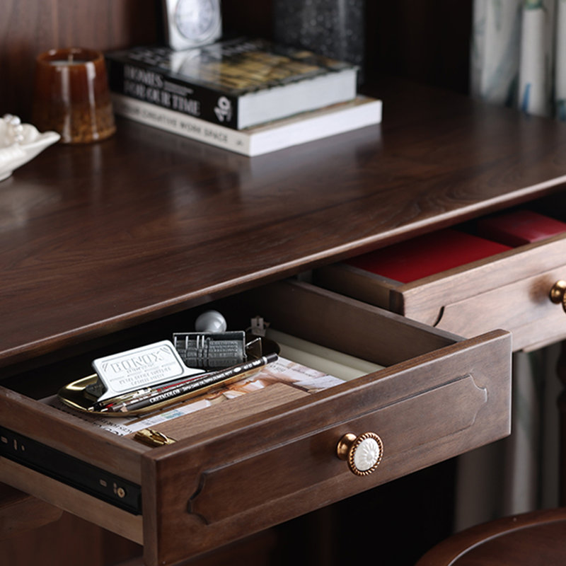 Un bureau antique en bois avec des poignées en cuivre