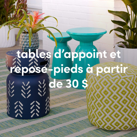 Photo lifestyle extérieure de tables d'appoint en métal à motifs bleu marine et sarcelle et d'un pouf géométrique vert à partir de 30 $.