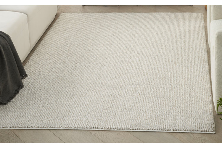 A cream-colored area rug with a berber weave.