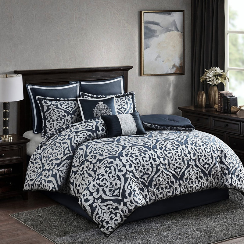 Couette bleu marine et argent pour lit King. Ensemble de 8 pièces avec garniture. Comprend 1 couette, 2 taies d'oreiller carrées, des coussins décoratifs et un cache-sommier. Motif texturé pour une touche d'élégance. Utilisation toute l'année.