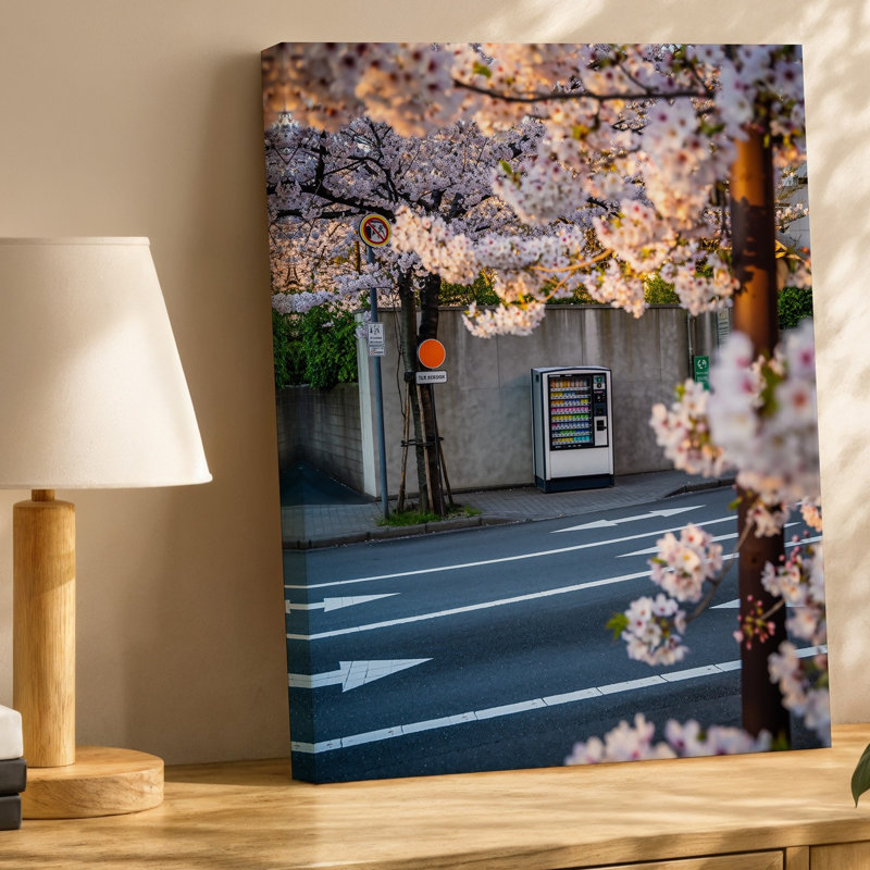 Toile d'une scène urbaine sereine capturée au printemps avec des fleurs de cerisier délicates encadrant l'avant-plan avec une toile murale rose tendre