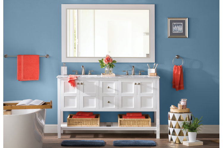 two small bathroom rugs in front of a white double vanity in a dark blue bathroom