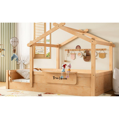Lit simple au sol en forme de maison, avec garde-corps, toit, plateau intégré pour développer les compétences organisationnelles et panneau installé ludique pour ranger les curiosités du coucher,