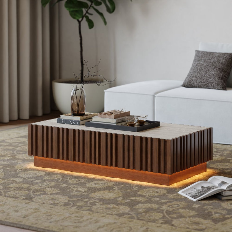 Table basse de 119 cm (47 po) en frêne à lattes, avec éclairage DEL à intensité variable et plateau en pierre frittée et rangement intégré.