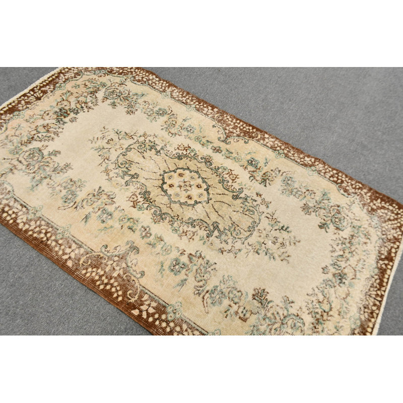 Tapis turc de style antique avec un élégant motif floral dans des tons bruns et beiges, idéal pour un décor traditionnel