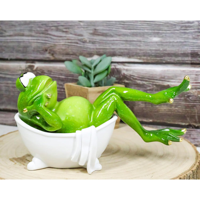 Figurine grenouille avec clous trempés dans une baignoire