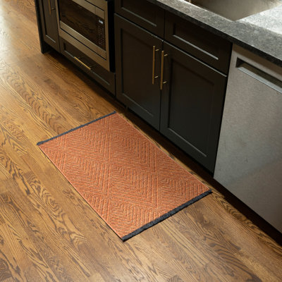 Tapis orange lavable à la machine Breneisha