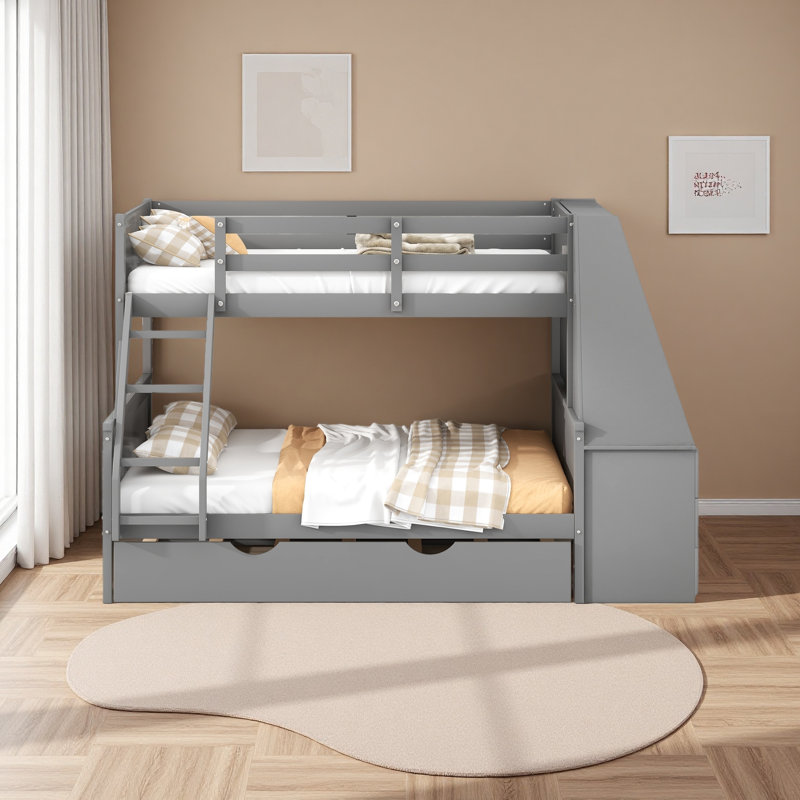 Lit simple superposé au dessus d'un lit double avec lit gigogne et bureau intégré, trois tiroirs de rangement et une tablette