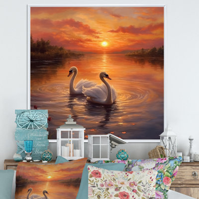 Coucher de soleil romantique avec deux cygnes blancs