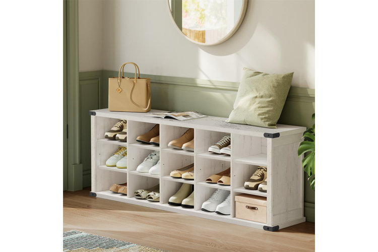 entryway with white shoe storage bench filled with shoes