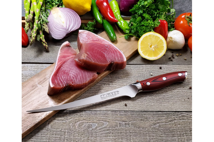 boning knife on a cutting board with pieces of fish