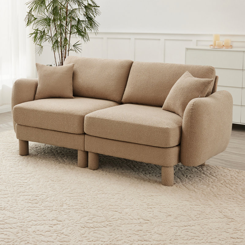 Confortable canapé en tissu à 2 boucles avec système de ressorts et coussins décoratifs pour se détendre dans un espace optimal en forme de coquillage