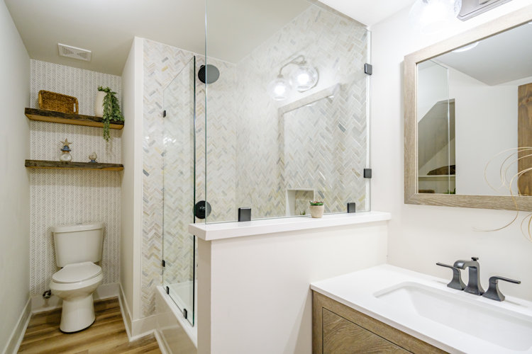 farmhouse bathroom renovation with a glass shower enclosure with a pony wall