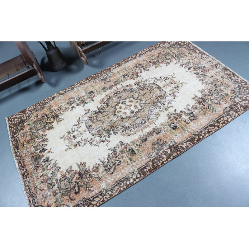 Tapis turc classique classique avec un élégant motif floral dans des tons de terre discrets pour un style de décoration traditionnelle