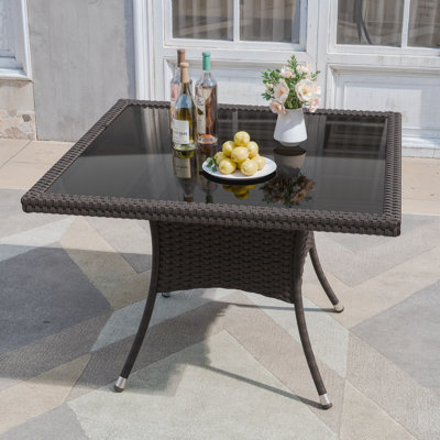 Hemraj Outdoor Square Rattan Dining Table With Glass Top And Curved Design