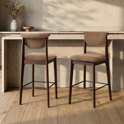 Tabouret de bar rembourré de style milieu du siècle, avec structure en bois massif, dossier incurvé et siège en tissu doux, idéal pour un îlot de cuisine moderne.