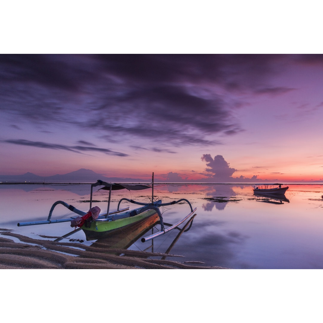 Dramatischer Sonnenaufgang in Bali mit Holzbooten