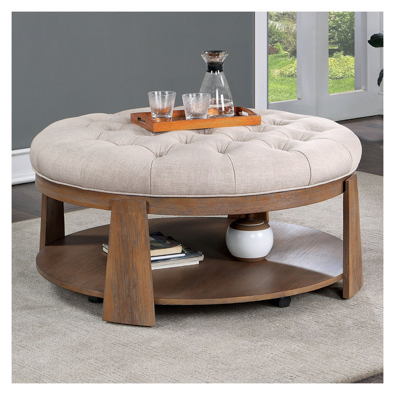 Table basse ronde transitionnelle avec siège en lin rembourré et tablette ouverte, fabrication en bois massif avec finition beige