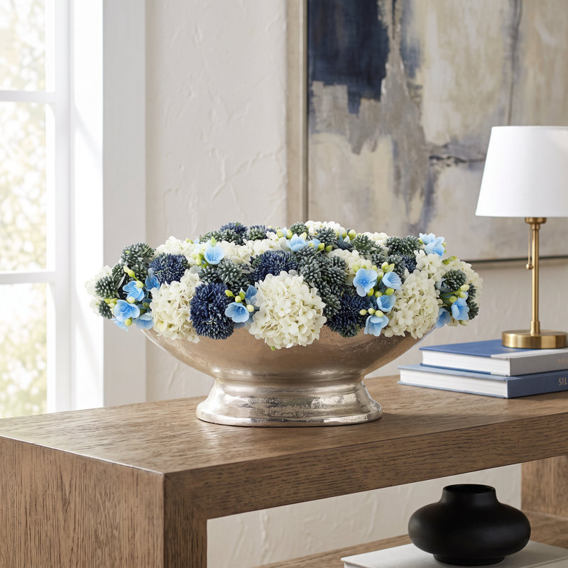 Hortensias et orpins disposés dans un vase en métal