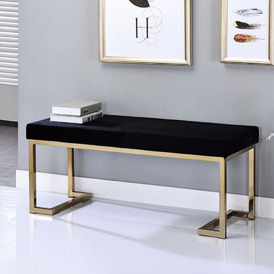 Banc élégant pour la chambre à coucher avec siège rembourré noir et base au fini champagne doré