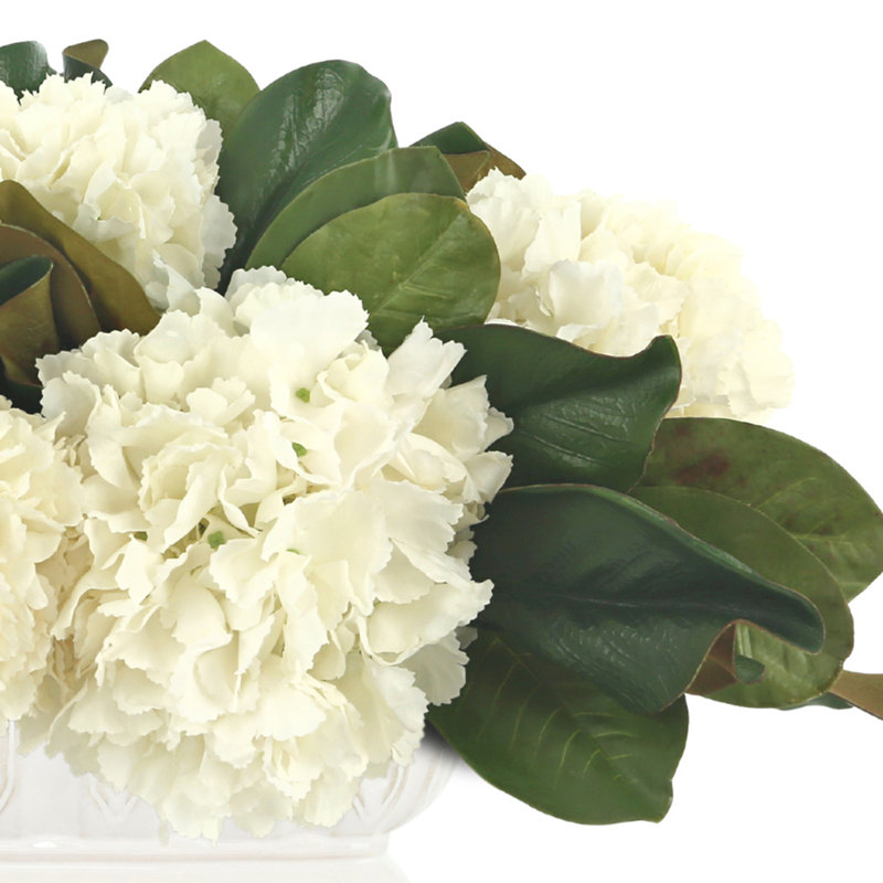 Arrangement floral avec hortensias et feuilles de magnolia