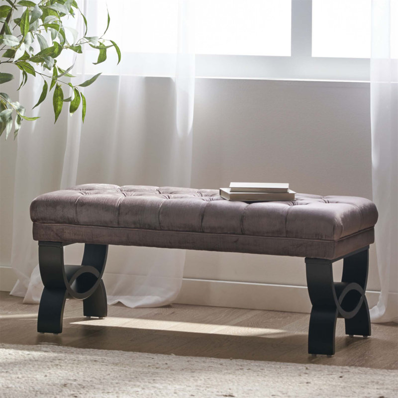 Luxueux repose-pieds capitonné classique avec coutures en losanges et pieds semi-circulaires modernes pour une décoration intérieure élégante