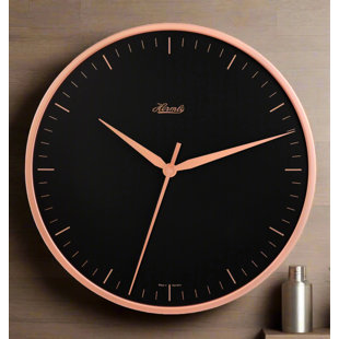 Sleek, modern wall clock in black with rose gold Arabic Numerals.  Quartz time only movement.