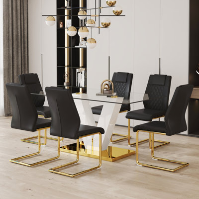 Ensemble de table et de chaises Ensemble de salle à manger en verre trempé transparent de luxe subtil - avec 6 chaises en polyuréthane noir avec pieds en métal en C doré. Ajoutant une atmosphère chaleureuse et douce à votre famille. (Ensemble de sa