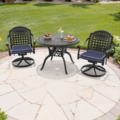 Ensemble bistro 3 pièces comprenant une table de salle à manger ronde de 100 cm (39,37 po) avec trou pour parasol et 2 chaises pivotantes avec coussins bleus.
