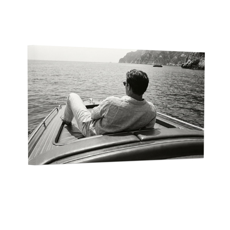 Homme de mode assis sur un bateau faisant face à la mer, H 32 po x l 48 po