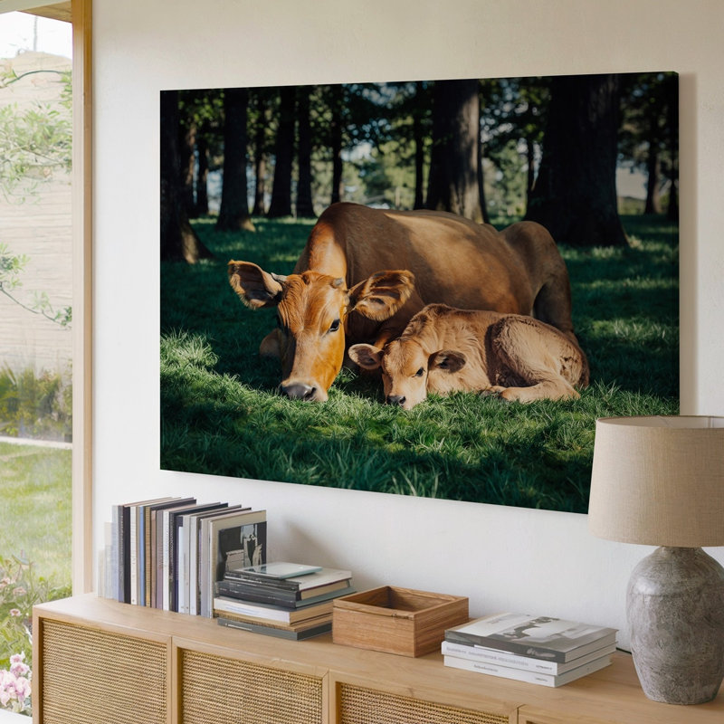 Toile dans un paysage pastoral serein, une mère vache s'incline sur un art épais, un tapis épais de gazon émeraude
