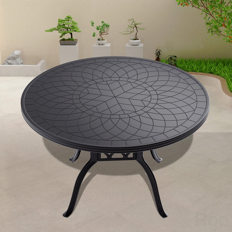 Table de salle à manger en fonte d'aluminium avec cadre noir et texture sculptée sur le plateau de table