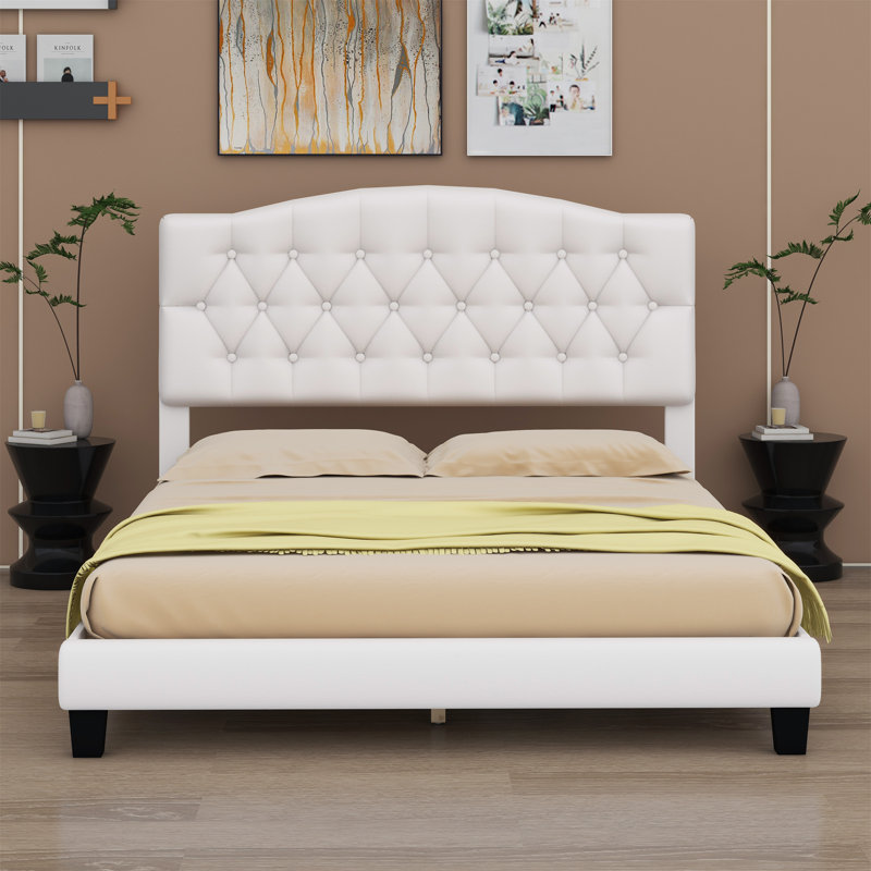 Lit plateforme tapissier avec tête de lit courbée et détails capitonnés