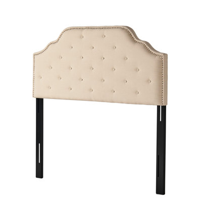 La grande et grande tête de lit, de couleur beige, est dotée d'un élégant capitonnage à boutons et d'un magnifique motif à losanges de longue durée