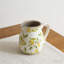 Ceramic Pitcher Vase With Lemon Motif, Rustic Textured Rim, Distressed Finish, And Versatile Decorative Functionality For Tabletops And Shelving.
